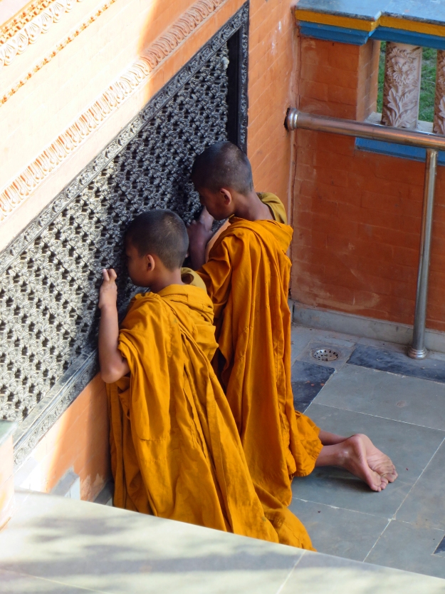 Quick -- notice the carved wooden lattices over the windows before your thoughts move on to curiously ponder what these little monks are looking at.  By the time I finished photographing them, there was a crowd of 8-10 boys peeking in the window.  I never did figure out what they were looking at.