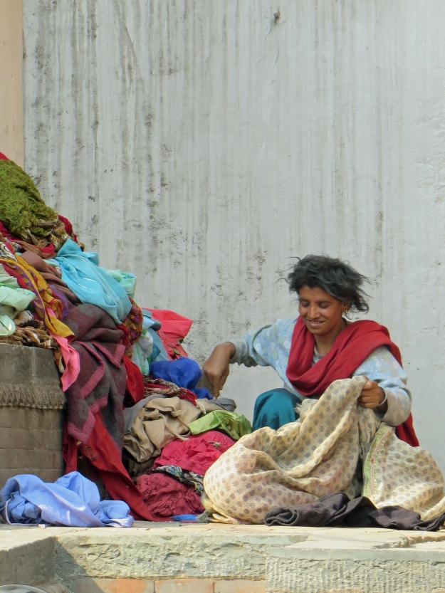 I was struck by this woman's beautiful smile while she sorted through these old clothes on the street.  She seems happy.