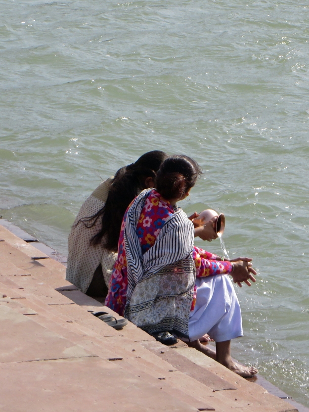 These women are carefully filling plastic bottles with water from the Ganges.