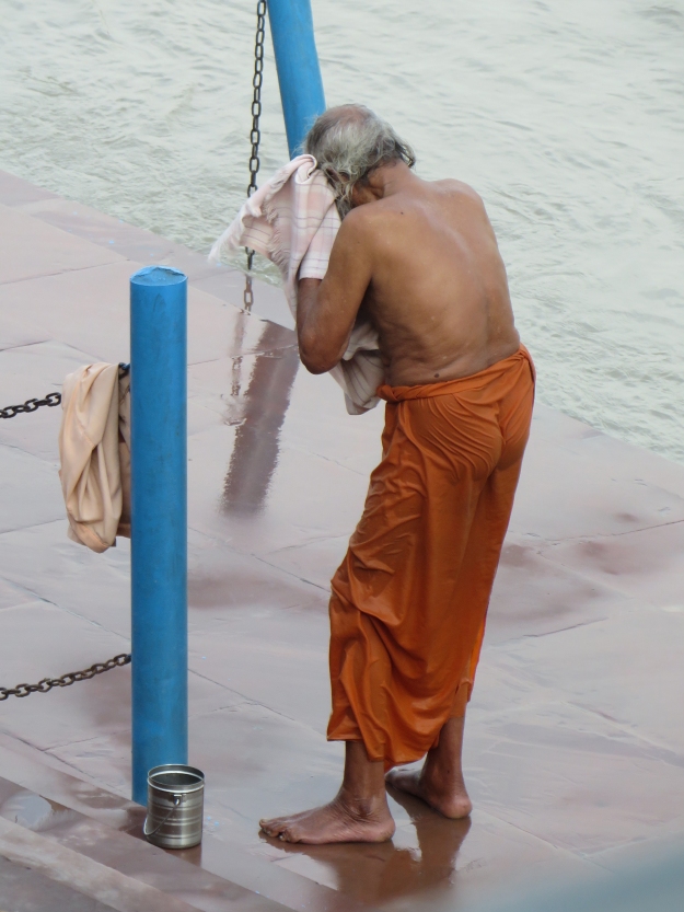 A sadhu (holy man) performs his morning toiletries on the river's banks.