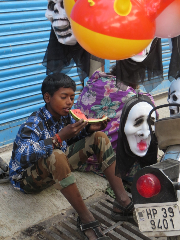 I have no idea why this kid and his mom were selling what looked like Halloween masks.  But, with him taking a watermelon break, it made for a terrific photo.